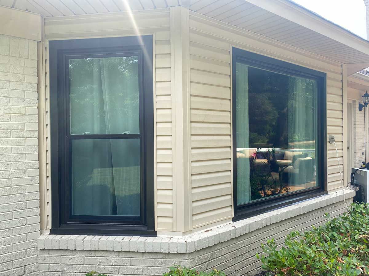 Black vinyl windows installed on an old home