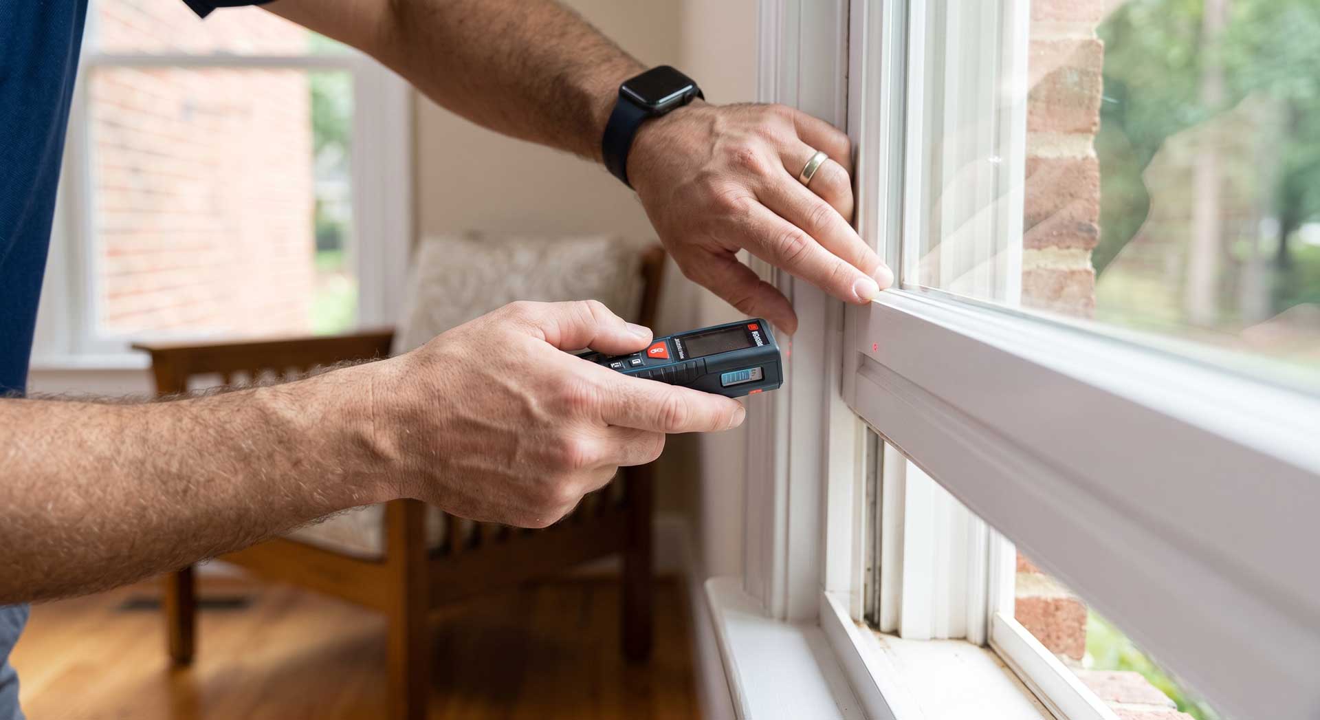 Window replacement installer inspecting a home window.